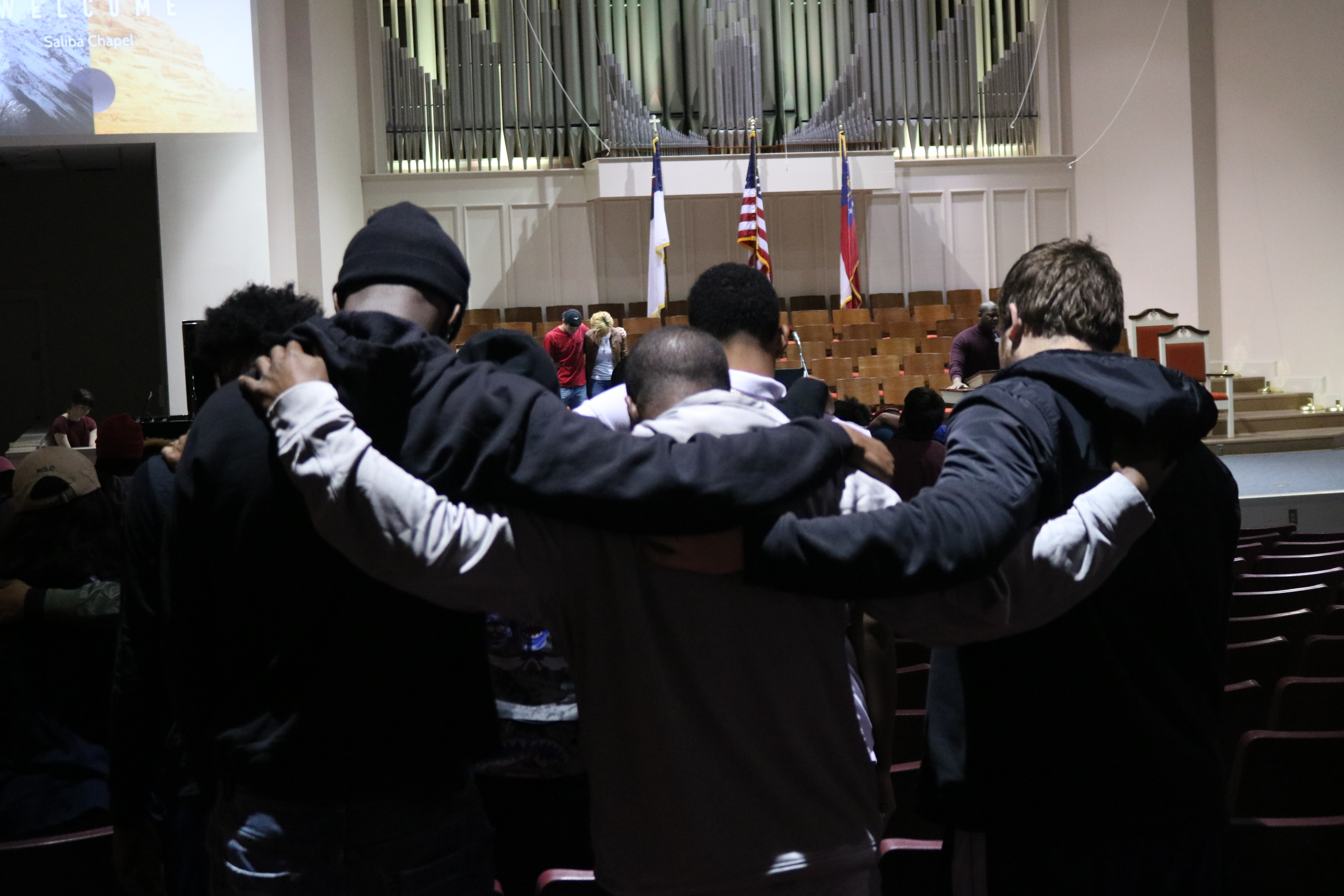 A group of Brewton-Parker students link arms as they pray during the February 13 chapel service. Photo Credit: Jose Carrillo-Garcia